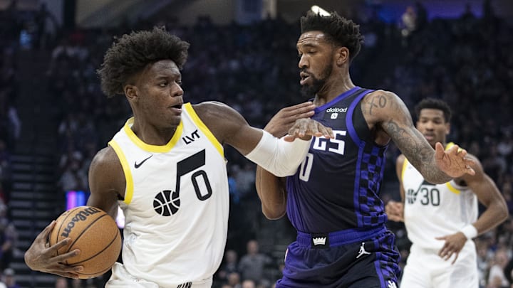 December 16, 2023; Sacramento, California, USA; Utah Jazz forward Taylor Hendricks (0) dribbles the basketball against Sacramento Kings guard Malik Monk (0) during the first quarter at Golden 1 Center. Mandatory Credit: Kyle Terada-Imagn Images
