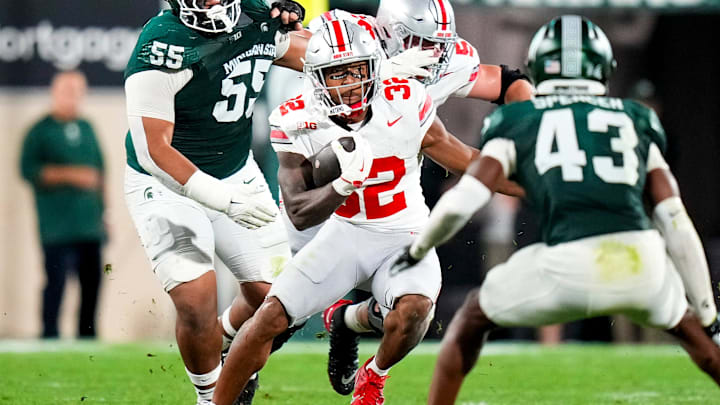 Sep 28, 2024; East Lansing, Michigan, USA; Ohio State Buckeyes running back TreVeyon Henderson (32) runs the ball against Michigan State Spartans defensive back Malik Spencer (43) in the first half at Spartan Stadium on Saturday.