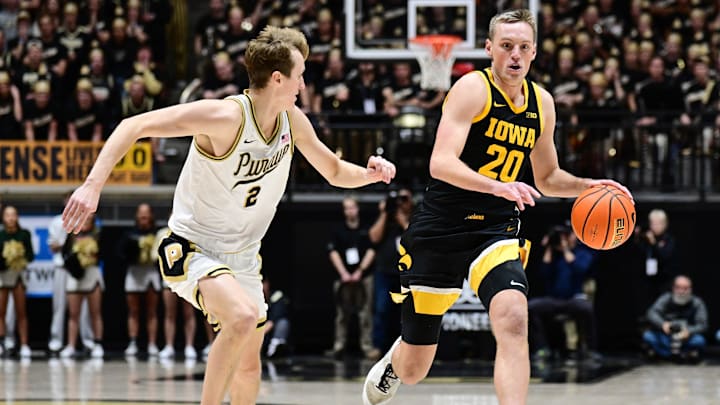 Iowa Hawkeyes forward Payton Sandfort (20) dribbles in front of Purdue Boilermakers guard Fletcher Loyer (2)