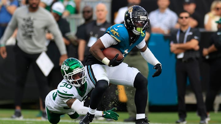 Jacksonville Jaguars running back Travis Etienne Jr. (1) rushes for yards against New York Jets cornerback Michael Carter II (30) during the second quarter Sunday, Dec. 15, 2024 at EverBank Stadium in Jacksonville, Fla. [Corey Perrine/Florida Times-Union]
