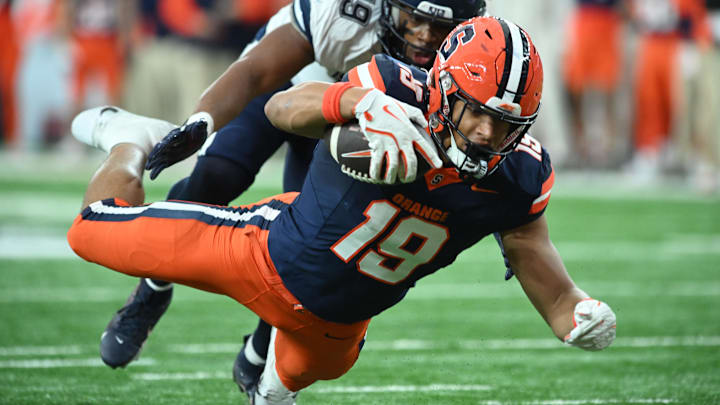 Nov 23, 2024; Syracuse, New York, USA; Syracuse Orange tight end Oronde Gadsden II (19) is tackled by Connecticut Huskies linebacker Langston Hardy (19) after making a catch in the first quarter at the JMA Wireless Dome.  