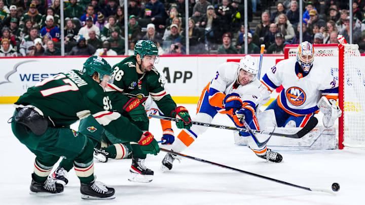 Jan 15, 2024; Saint Paul, Minnesota, USA; New York Islanders defenseman Adam Pelech (3) pokes the puck away from Minnesota Wild right wing Mats Zuccarello (36) and left wing Kirill Kaprizov (97) during the second period at Xcel Energy Center. Mandatory Credit: Brace Hemmelgarn-Imagn Images
