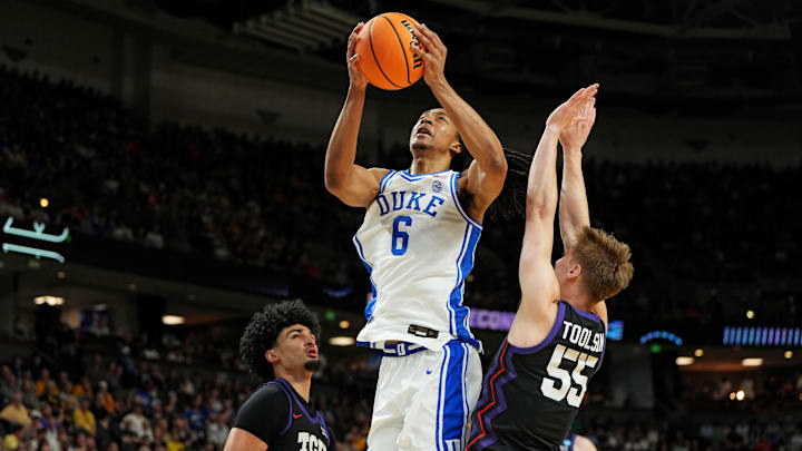 Mar 21, 2026; Greenville, SC, USA; Duke Blue Devils forward Maliq Brown (6) goes for a layup against Texas Christian University Horned Frogs forward David Punch (15) and guard Tanner Toolson (55).