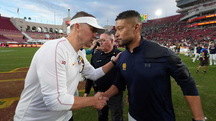 Nov 30, 2024; Los Angeles, California, USA; Southern California Trojans head coach Lincoln Riley and Notre Dame Fighting Irish head coach Marcus Freeman shake hands after the game at United Airlines Field at Los Angeles Memorial Coliseum. Mandatory Credit: Kirby Lee-Imagn Images Nov 30, 2024; Los Angeles, California, USA; Southern California Trojans head coach Lincoln Riley and Notre Dame Fighting Irish head coach Marcus Freeman shake hands after the game at United Airlines Field at Los Angeles Memorial Coliseum. Mandatory Credit: Kirby Lee-Imagn Images