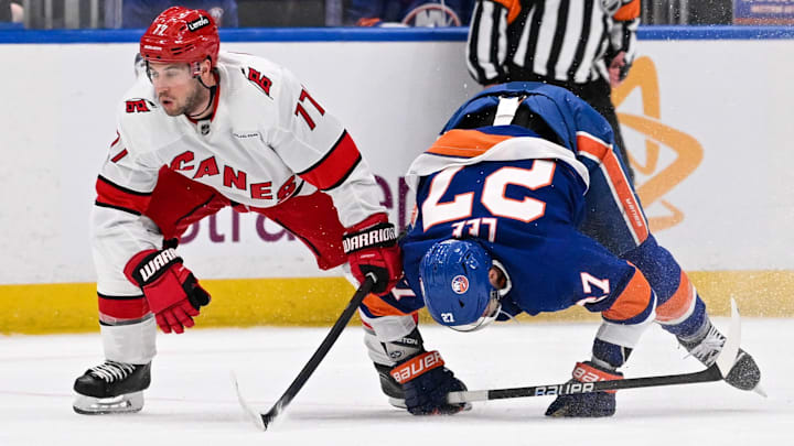 Apr 25, 2024; Elmont, New York, USA;  Carolina Hurricanes defenseman Tony DeAngelo (77) and New York Islanders left wing Anders Lee (27) collide during the second period in game three of the first round of the 2024 Stanley Cup Playoffs at UBS Arena. Mandatory Credit: Dennis Schneidler-Imagn Images