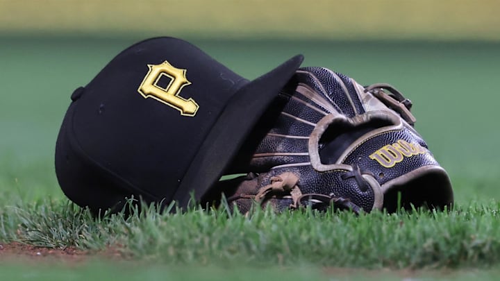 Sep 16, 2025; Pittsburgh, Pennsylvania, USA; A hat and glove belonging to Pittsburgh Pirates third baseman Jared Triolo (not pictured) on the field against the Chicago Cubs during the sixth inning at PNC Park. Mandatory Credit: Charles LeClaire-Imagn Images