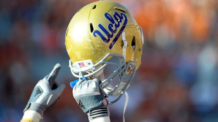 Sept 25, 2010; Austin, TX, USA; A member of the UCLA Bruins holds up his helmet to acknowledge their fans against the Texas Longhorns during the fourth quarter at Texas Memorial Stadium. UCLA beat Texas 34-12. Mandatory Credit: Brendan Maloney-Imagn Images Sept 25, 2010; Austin, TX, USA; A member of the UCLA Bruins holds up his helmet to acknowledge their fans against the Texas Longhorns during the fourth quarter at Texas Memorial Stadium. UCLA beat Texas 34-12. Mandatory Credit: Brendan Maloney-Imagn Images