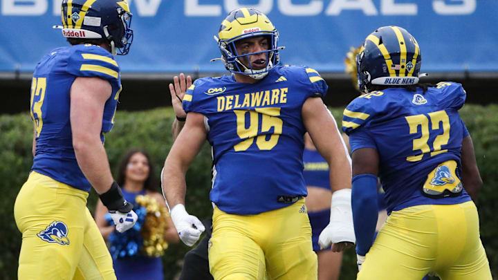 Delaware's Melkart Abou-Jaoude celebrates a third quarter sack with Trace Scott (left) and Marje Mulumba in the Blue Hens' 49-0 win at Delaware Stadium, Saturday, Sept. 28, 2024.