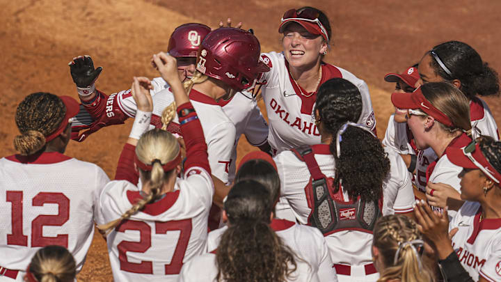 Oklahoma infielder Sydney Barker (77) reacts with teammates after hitting a home run against Arkansas at Jack Turner Softball Stadium.