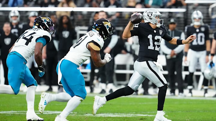 Dec 22, 2024; Paradise, Nevada, USA; Las Vegas Raiders quarterback Aidan O'Connell (12) is flushed out of the pocket by Jacksonville Jaguars defensive end Travon Walker (44) and Jacksonville Jaguars defensive end Josh Hines-Allen (41) during the second quarter at Allegiant Stadium. Mandatory Credit: Stephen R. Sylvanie-Imagn Images