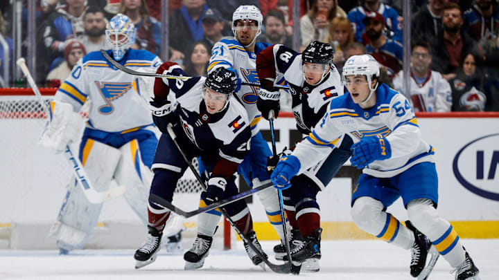 Dec 31, 2025; Denver, Colorado, USA; Colorado Avalanche center Ross Colton (20) and center Jack Drury (18) battle for position with St. Louis Blues defenseman Matthew Kessel (51) as right wing Dalibor Dvorsky (54) defends in the first period at Ball Arena. Mandatory Credit: Isaiah J. Downing-Imagn Images