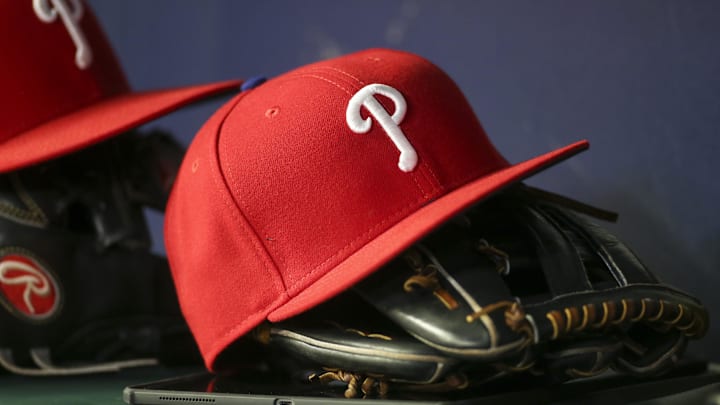 May 25, 2022; Atlanta, Georgia, USA; Detailed view of a Philadelphia Phillies hat and glove in the dugout against the Atlanta Braves in the eighth inning at Truist Park. Mandatory Credit: Brett Davis-Imagn Images