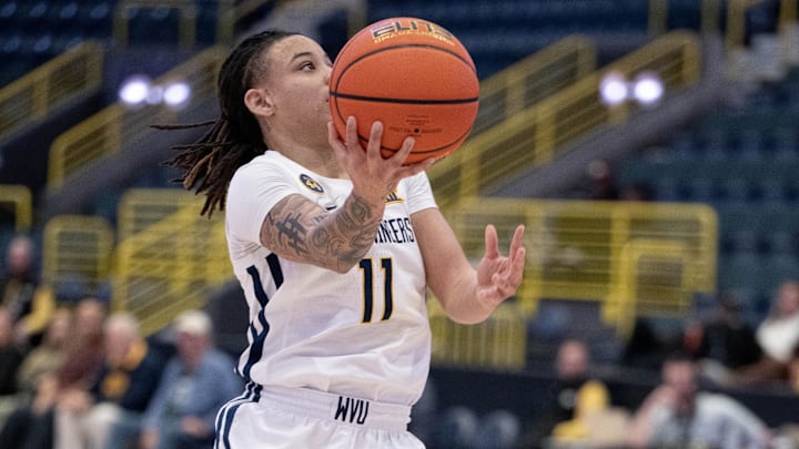 Dec 1, 2024; Estero, FL, USA; West Virginia University JJ Quinerly (11) goes in for the layup over University of Texas Rori Harmon (3) during the first quarter of the Women's Gulf Coast Showcase at Hertz Arena. Mandatory Credit: Chris Tilley-Imagn Images
