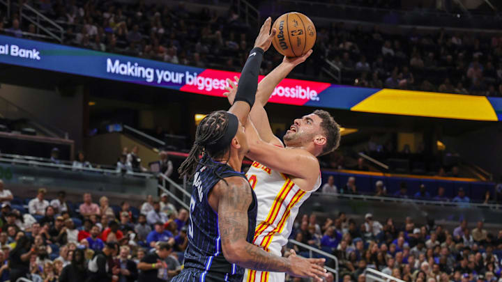 Apr 8, 2025; Orlando, Florida, USA; Atlanta Hawks forward Georges Niang (20) shoots against Orlando Magic forward Paolo Banchero (5) during the second quarter at Kia Center. Mandatory Credit: Mike Watters-Imagn Images