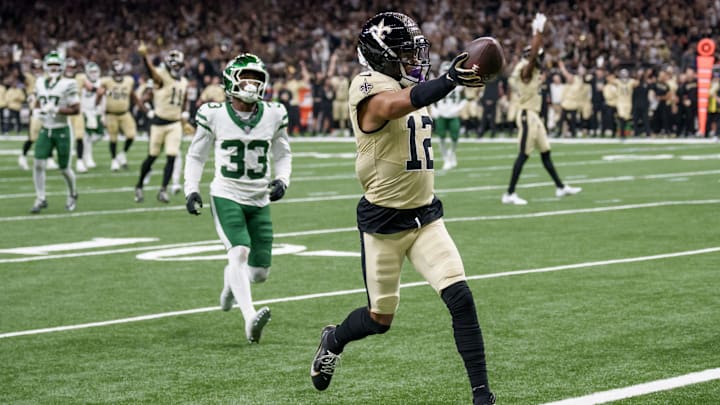 Dec 21, 2025; New Orleans, Louisiana, USA; New Orleans Saints wide receiver Chris Olave (12) crosses the goal line for a touchdown against New York Jets cornerback Jordan Clark (33) during the third quarter at Caesars Superdome. Mandatory Credit: Matthew Hinton-Imagn Images