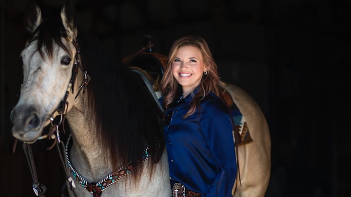 Brittany Fellows posing with one of her barrel horses. 