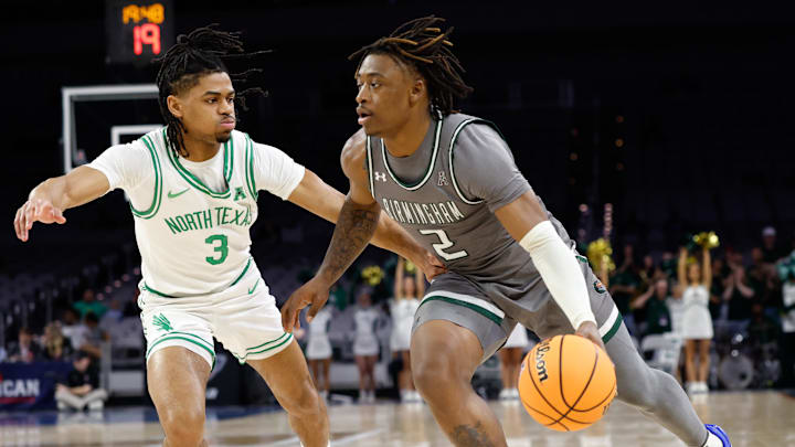 Mar 15, 2025; Fort Worth, TX, USA;  UAB Blazers guard Ja'Borri McGhee (2) drives to the basket as North Texas Mean Green guard Jasper Floyd (3) defends during the first half at Dickies Arena. Mandatory Credit: Chris Jones-Imagn Images