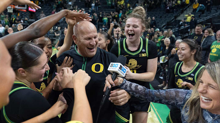 Oregon players mob coach Kelly Graves, center, during his TV interview after upsetting Baylor at Matthew Knight Arena in Eugene.