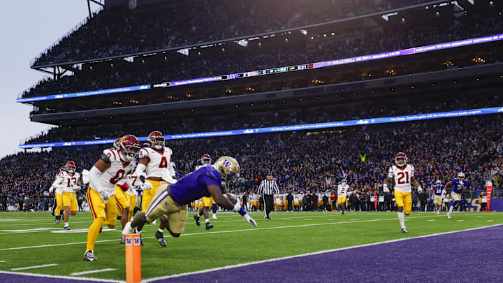 Nov 2, 2024; Seattle, Washington, USA; Washington Huskies running back Jonah Coleman (1) rushes for a touchdown against USC Trojans safety Akili Arnold (0) and linebacker Easton Mascarenas-Arnold (4) during the first quarter at Alaska Airlines Field at Husky Stadium. Mandatory Credit: Joe Nicholson-Imagn Images Nov 2, 2024; Seattle, Washington, USA; Washington Huskies running back Jonah Coleman (1) rushes for a touchdown against USC Trojans safety Akili Arnold (0) and linebacker Easton Mascarenas-Arnold (4) during the first quarter at Alaska Airlines Field at Husky Stadium. Mandatory Credit: Joe Nicholson-Imagn Images