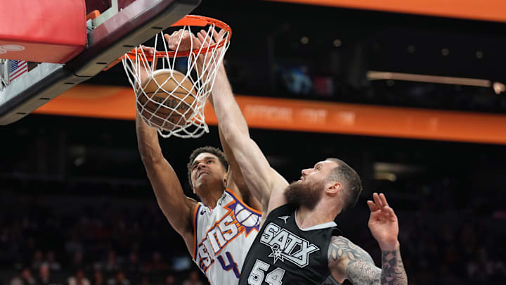 Apr 11, 2025; Phoenix, Arizona, USA; Phoenix Suns center Oso Ighodaro (4) dunks over San Antonio Spurs forward Sandro Mamukelashvili (54) during the second half at Footprint Center. Mandatory Credit: Joe Camporeale-Imagn Images