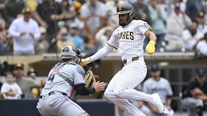 May 28, 2025; San Diego, California, USA; San Diego Padres right fielder Fernando Tatis Jr. (23) is tagged out at the plate by Miami Marlins catcher Nick Fortes (4) during the fourth inning at Petco Park. Mandatory Credit: Denis Poroy-Imagn Images