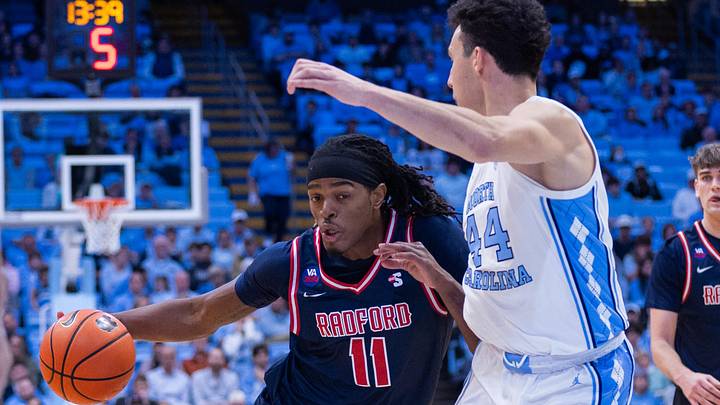 Nov 11, 2025; Chapel Hill, North Carolina, USA; Radford Highlanders guard Jr. Dennis Parker (11) drives on North Carolina Tar Heels guard Luka Bogavac (44) during the first half at Dean E. Smith Center. Mandatory Credit: Scott Kinser-Imagn Images