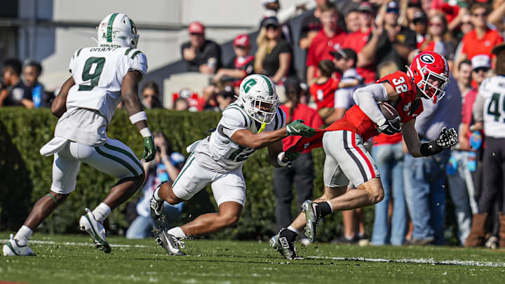 Nov 22, 2025; Athens, Georgia, USA; Georgia Bulldogs running back Cash Jones (32) is grabbed by the shirt and spun around by Charlotte 49ers defensive back CJ Clinkscales (12) during the first half at Sanford Stadium. Mandatory Credit: Dale Zanine-Imagn Images