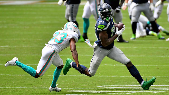 Oct 4, 2020; Miami Gardens, Florida, USA; Seattle Seahawks wide receiver DK Metcalf (14) runs with the ball around Miami Dolphins cornerback Noah Igbinoghene (23) during the first half at Hard Rock Stadium. Mandatory Credit: Jasen Vinlove-Imagn Images