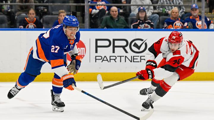Apr 14, 2026; Elmont, New York, USA;  Carolina Hurricanes center Skyler Brind'amour (76) attempts a shot defended by New York Islanders left wing Anders Lee (27) during the third period at UBS Arena. Mandatory Credit: Dennis Schneidler-Imagn Images