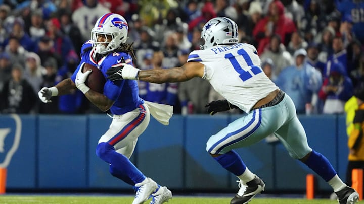 Buffalo Bills running back James Cook runs the ball pressured by Dallas Cowboys linebacker Micah Parsons.
