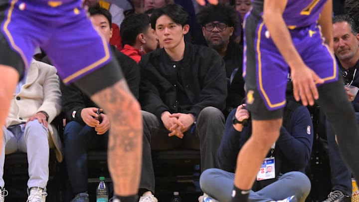 Jan 21, 2025; Los Angeles, California, USA;  Los Angeles Dodgers pitcher Roki Sasaki, center, attends the game between the Los Angeles Lakers and the Washington Wizards at Crypto.com Arena. Mandatory Credit: Jayne Kamin-Oncea-Imagn Images
