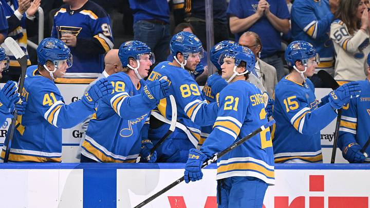 Oct 20, 2026; St. Louis, Missouri, USA;  St. Louis Blues right wing Jimmy Snuggerud (21) is congratulated by teammates after scoring against the Winnipeg Jets during the first period at Enterprise Center.  Mandatory Credit: Jeff Le-Imagn Images