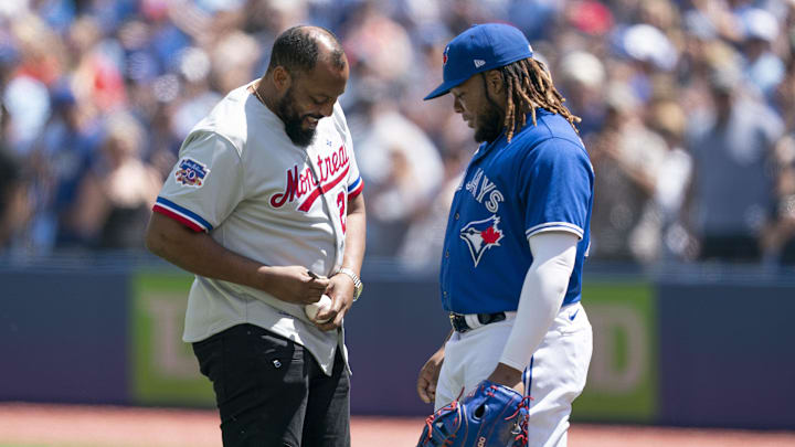 Jul 2, 2022; Toronto, Ontario, CAN; Montreal Expos player Vladimir Guerrero Sr. signs a ball for Toronto Blue Jays designated hitter Vladimir Guerrero Jr. (27) before the game against the Tampa Bay Rays at Rogers Centre.