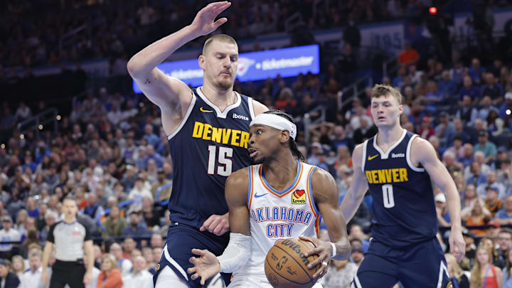 Mar 10, 2025; Oklahoma City, Oklahoma, USA; Denver Nuggets center Nikola Jokic (15) defends a drive by Oklahoma City Thunder guard Shai Gilgeous-Alexander (2) during the second half at Paycom Center. Mandatory Credit: Alonzo Adams-Imagn Images