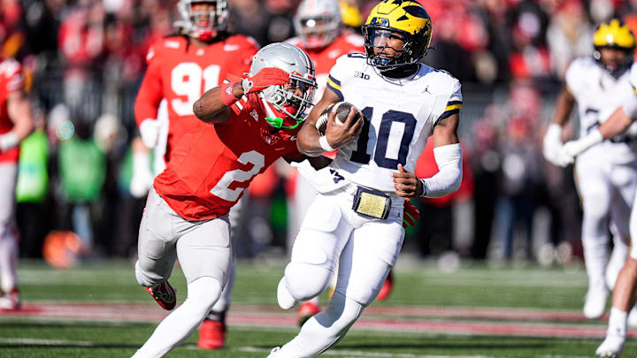 Michigan quarterback Alex Orji (10) runs against Ohio State safety Caleb Downs (2) during the first half at Ohio Stadium Michigan quarterback Alex Orji (10) runs against Ohio State safety Caleb Downs (2) during the first half at Ohio Stadium