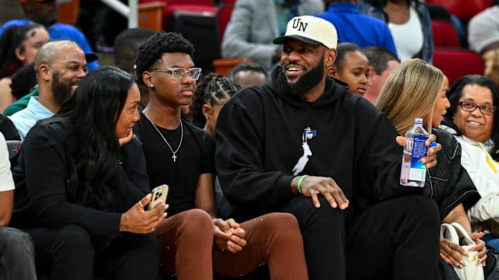 Mar 28, 2023; Houston, TX, USA; Los Angeles Lakers forward LeBron James sits with his wife Savannah James (right), son Bryce Maximus James (left) and his mother Gloria Marie James (left) court side of the between the McDonald's All American East and the McDonald's All American West at Toyota Center. Mandatory Credit: Maria Lysaker-Imagn Images