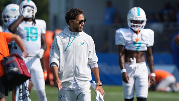 Miami Dolphins coach Mike McDaniels talks with the wide receivers during joint practice with the Detroit Lions at the Lions headquarters and training facility in Allen Park, Thursday, Aug. 14, 2025.