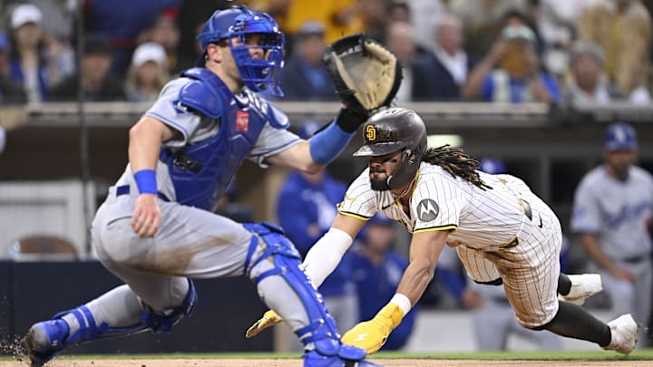 Jun 10, 2025; San Diego, California, USA; San Diego Padres right fielder Fernando Tatis Jr. (23) scores ahead of the throw to Los Angeles Dodgers catcher Dalton Rushing (68) during the third inning at Petco Park. Mandatory Credit: Denis Poroy-Imagn Images