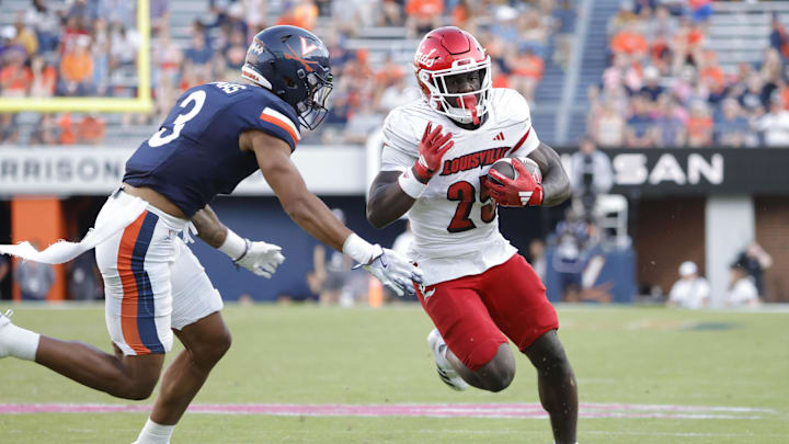 Oct 12, 2024; Charlottesville, Virginia, USA; Louisville Cardinals running back Isaac Brown (25) carries the ball past Virginia Cavaliers safety Corey Thomas Jr. (3) to score a touchdown during the second half at Scott Stadium. Mandatory Credit: Amber Searls-Imagn Images
