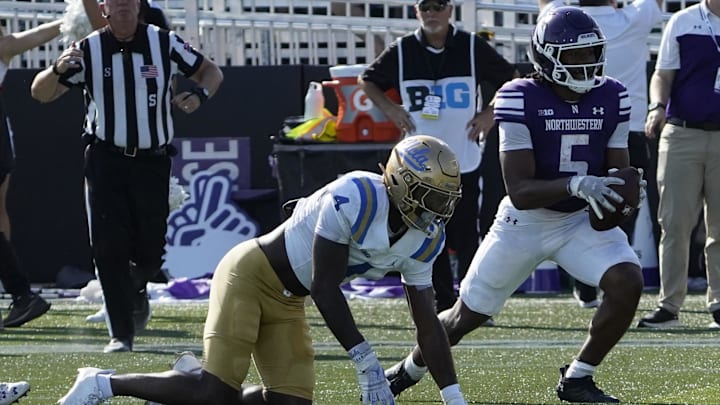 Sep 27, 2025; Evanston, Illinois, USA; Northwestern Wildcats running back Caleb Komolafe (5) scores a touchdown against the UCLA Bruins during the first half at Northwestern Medicine Field at Martin Stadium. Mandatory Credit: David Banks-Imagn Images