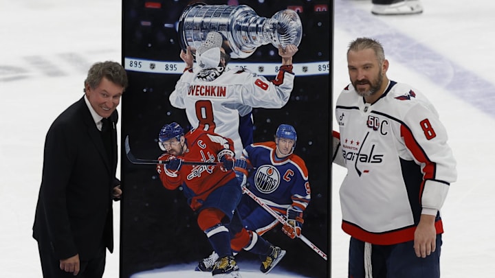 Apr 6, 2025; Elmont, New York, USA;  Washington Capitals left wing Alex Ovechkin (8) is honored with a painting by artist Tony Harris by former Canadian-American ice hockey player Wayne Gretzky after scoring in the during the second period against the New York Islanders at UBS Arena. Ovechkin scored the 895th goal of his career, breaking the NHL all-time career goals record previously held by Wayne Gretzky at UBS Arena. Mandatory Credit: Geoff Burke-Imagn Images