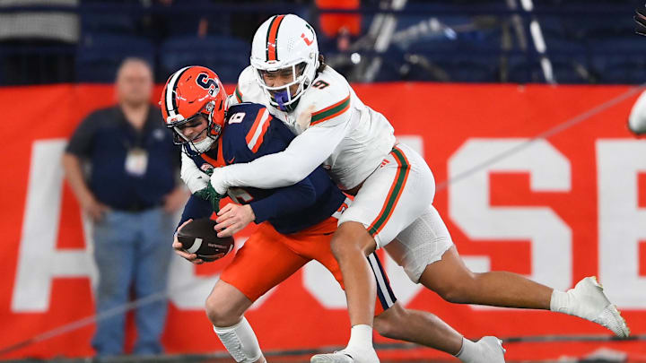 Nov 30, 2024; Syracuse, New York, USA; Miami Hurricanes defensive lineman Tyler Baron (9) sacks Syracuse Orange quarterback Kyle McCord (6) during the second half at the JMA Wireless Dome. Mandatory Credit: Rich Barnes-Imagn Images