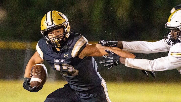 Buchholz Bobcats Justin Williams (13) eludes Oakleaf Knights Fareed Coleman (2) in the second half. The Buchholz Bobcats hosted the Oakleaf Knights at Citizens Field in Gainesville, FL on Friday, November 29 2024 in the Class 6A-Region 1 Final. The Bobcats defeated the Knights 25-19 and advance to the final four. [Doug Engle/Ocala Star Banner]