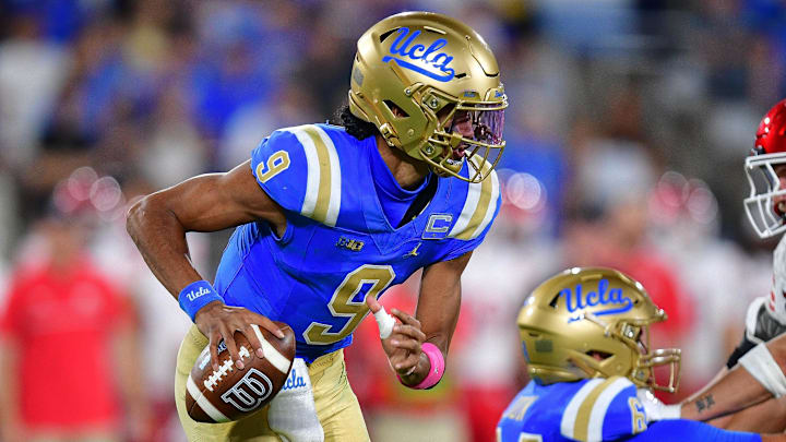 Aug 30, 2025; Pasadena, California, USA; UCLA Bruins quarterback Nico Iamaleava (9) runs the ball as offensive lineman Sam Yoon (64) provides coverage against Utah Utes linebacker Lander Barton (8) during the second half at Rose Bowl. Mandatory Credit: Gary A. Vasquez-Imagn Images