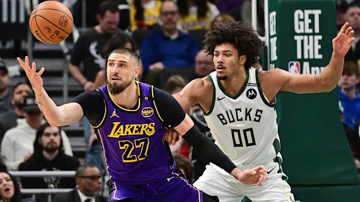 Mar 13, 2025; Milwaukee, Wisconsin, USA; Los Angeles Lakers center Alex Len (27) reaches for the ball against Milwaukee Bucks center Jericho Sims (00) in the second quarter at Fiserv Forum. Mandatory Credit: Benny Sieu-Imagn Images