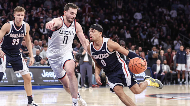 Gonzaga Bulldogs guard Ryan Nembhard (0) looks to drive past Connecticut Huskies forward Alex Karaban (11). 