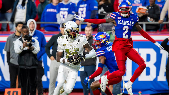 Nov 23, 2024; Kansas City, Missouri, USA;  Colorado wide receiver Travis Hunter (12) catches the ball ahead of Kansas cornerback Cobee Bryant (2) for a touchdown during the 3rd quarter between the Kansas Jayhawks and the Colorado Buffaloes at GEHA Field at Arrowhead Stadium. Mandatory Credit: Nick Tre. Smith-Imagn Images