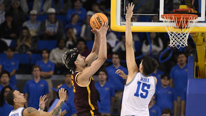 Feb 18, 2025; Los Angeles, California, USA; Minnesota Golden Gophers forward Dawson Garcia (3) drives between UCLA Bruins guard Kobe Johnson (0) and center Aday Mara (15) during the second half at Pauley Pavilion presented by Wescom. Mandatory Credit: Robert Hanashiro-Imagn Images Feb 18, 2025; Los Angeles, California, USA; Minnesota Golden Gophers forward Dawson Garcia (3) drives between UCLA Bruins guard Kobe Johnson (0) and center Aday Mara (15) during the second half at Pauley Pavilion presented by Wescom. Mandatory Credit: Robert Hanashiro-Imagn Images