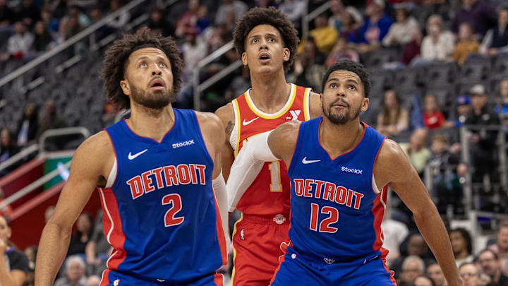 Nov 8, 2024; Detroit, Michigan, USA; Detroit Pistons guard Cade Cunningham (2) and forward Tobias Harris (12) block out Atlanta Hawks forward Jalen Johnson (1) during the first half at Little Caesars Arena. Mandatory Credit: David Reginek-Imagn Images