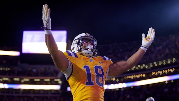 Nov 23, 2024; Baton Rouge, Louisiana, USA;  LSU Tigers running back Josh Williams (18) scores a touchdown against Vanderbilt Commodores linebacker Bryan Longwell (4) during the first half at Tiger Stadium. Mandatory Credit: Stephen Lew-Imagn Images